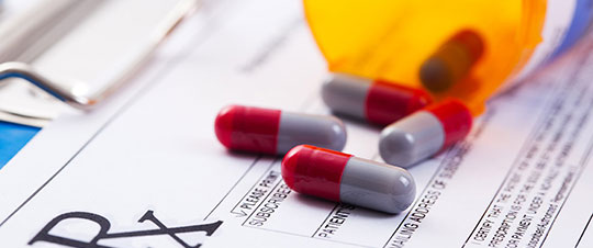 Pills spilled out of prescription bottle onto prescription form